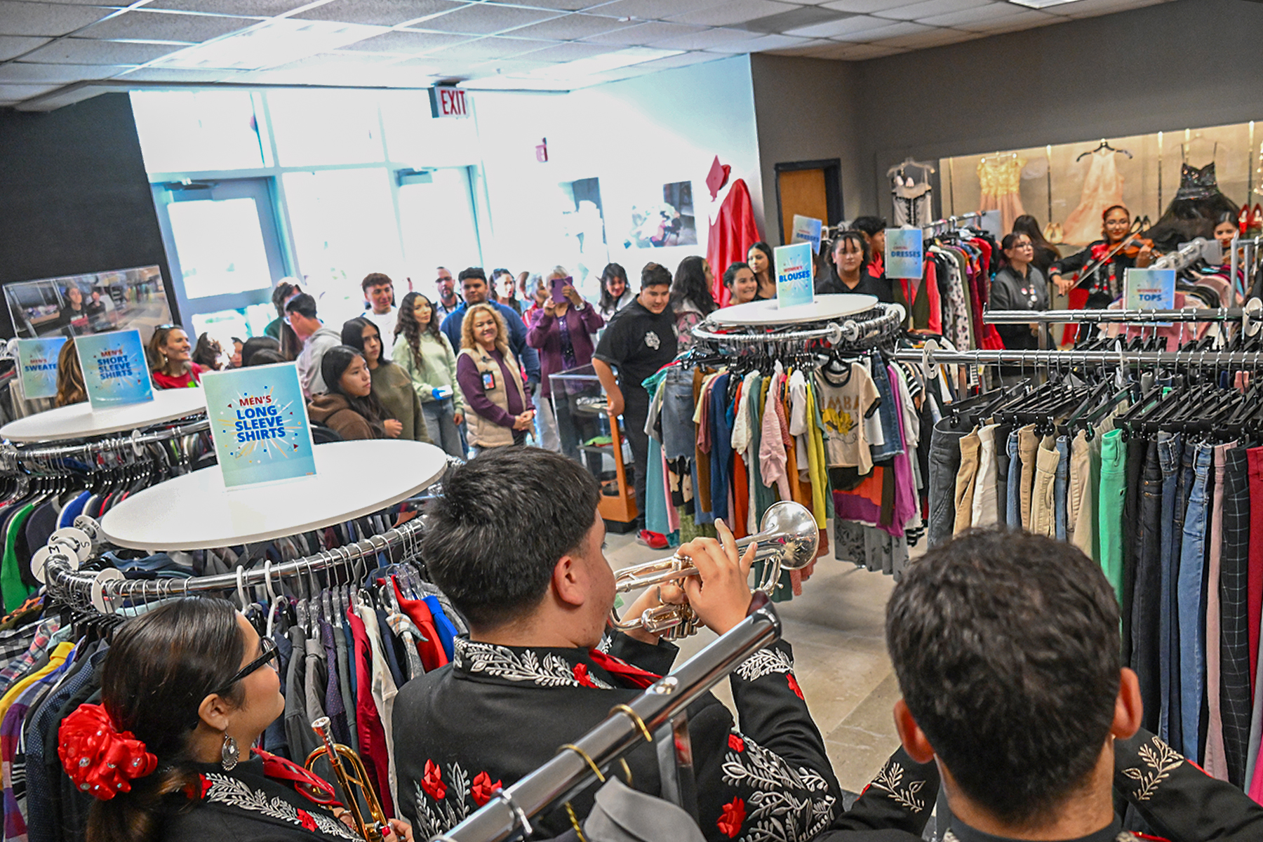 Student mariachi musicians play in the store filled with clothes