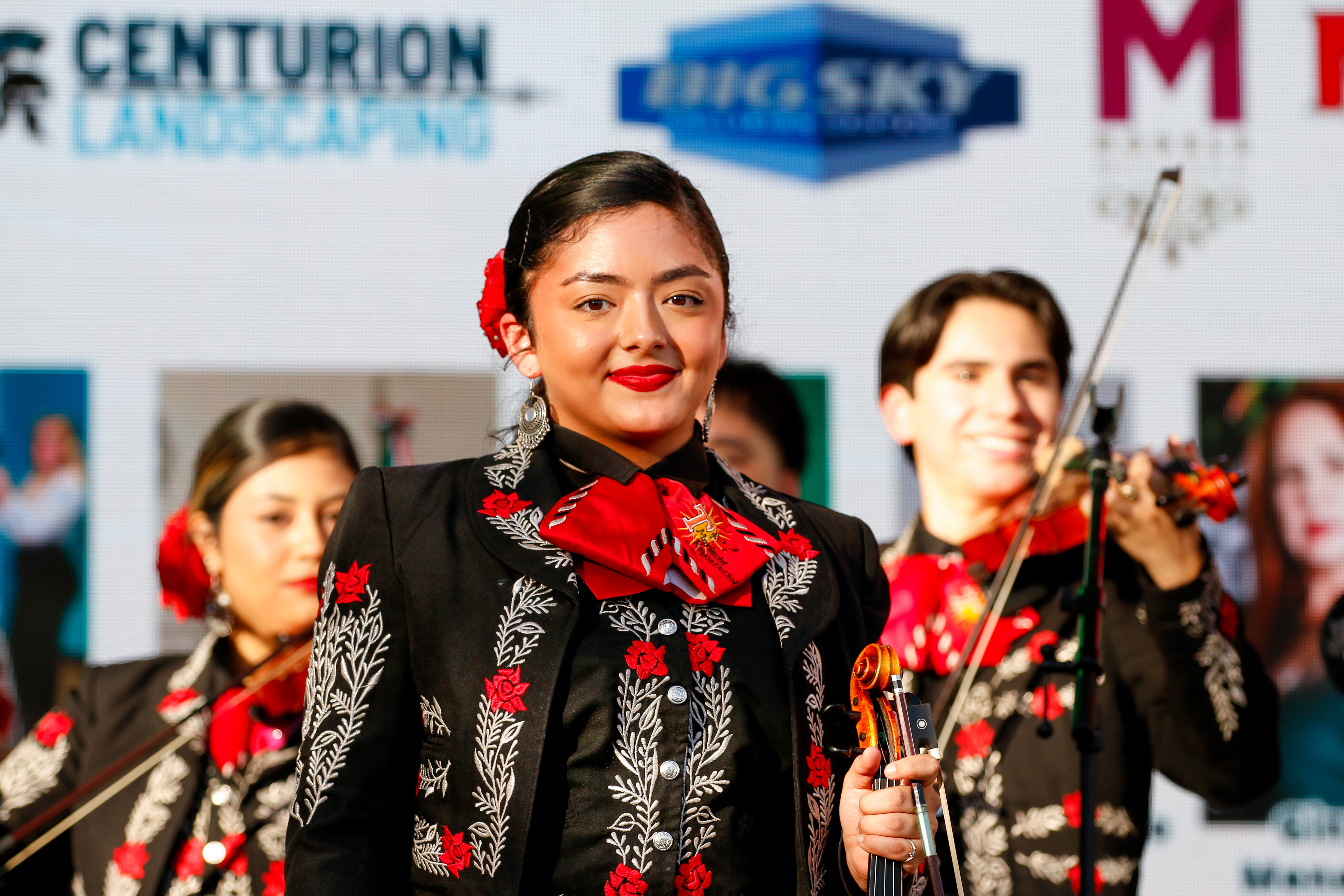 A member of Mariachi Rayos del Sol smiles while she gets ready to sing