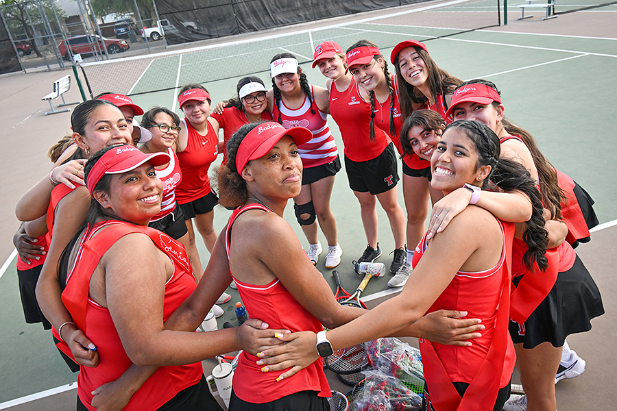 The girls tennis team poses in a circle