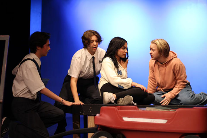 Student actors perform a scene on stage