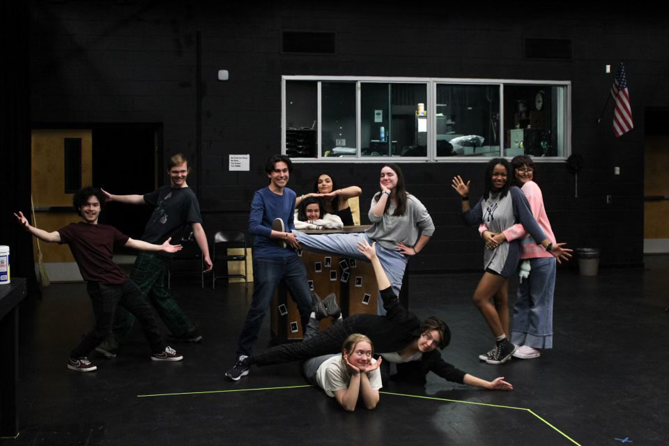 Student actors pose on stage
