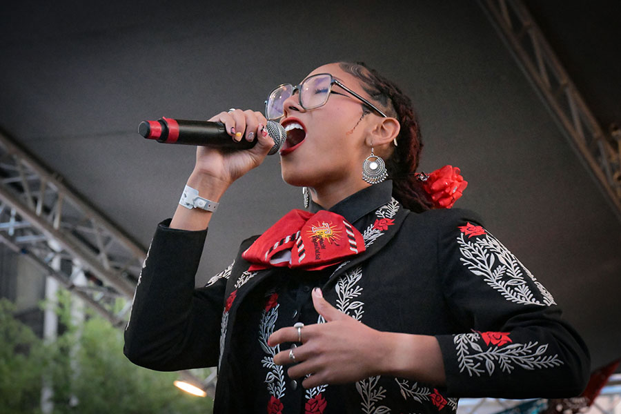 A teen girl in glasses sings passionately into a mic