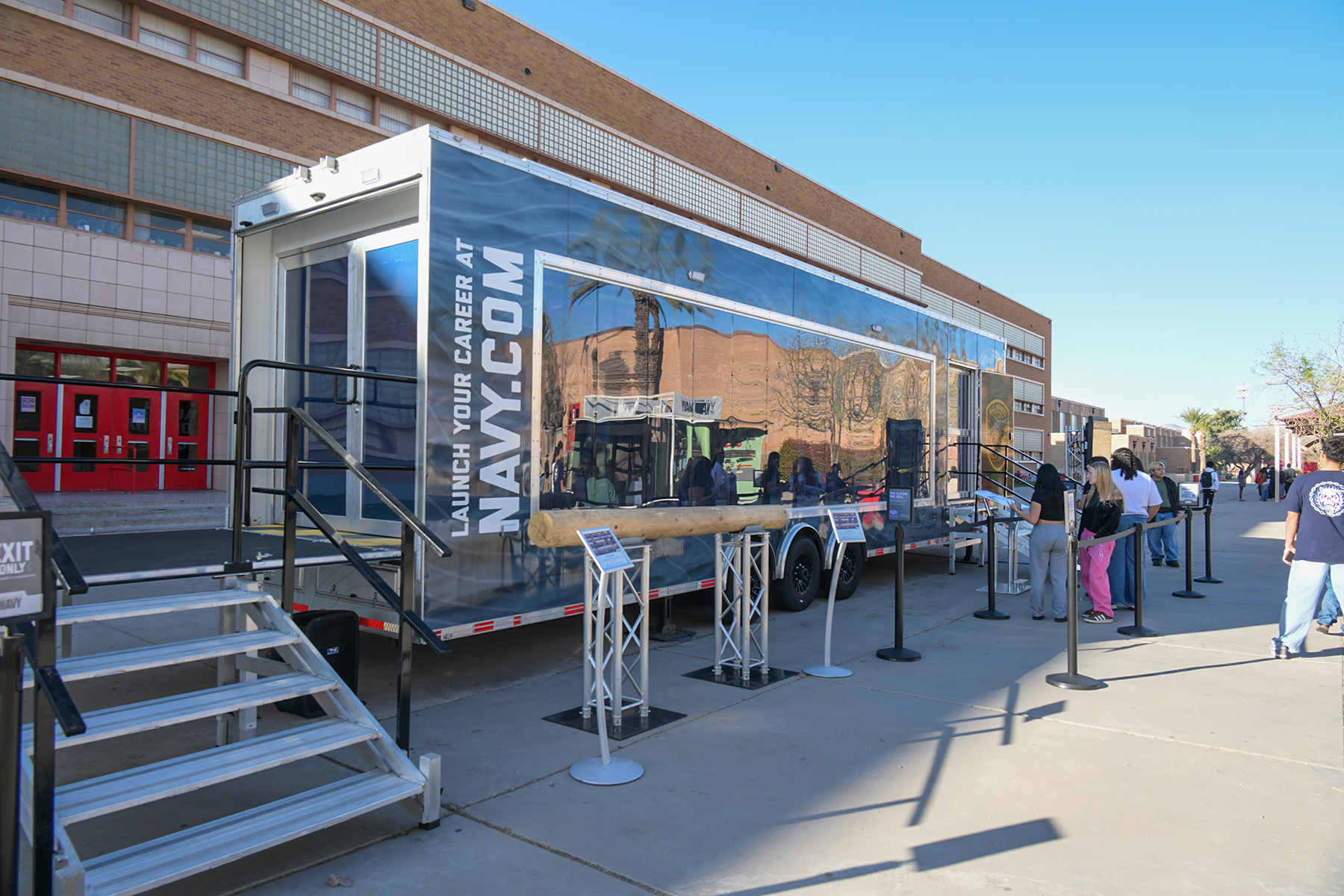 Students stand in line outside the U.S. Navy bus