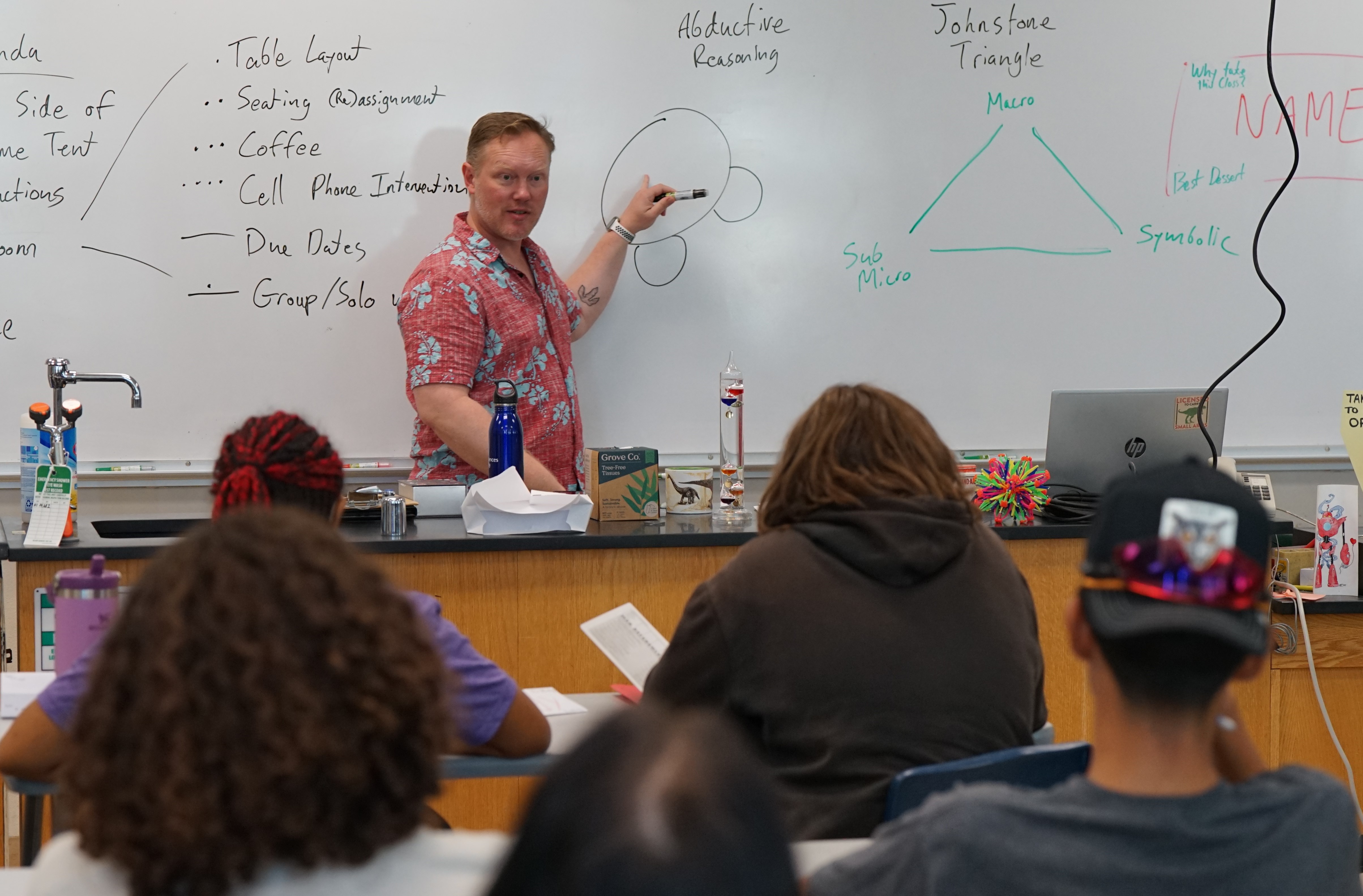 A teacher points to a diagram on the whiteboard 