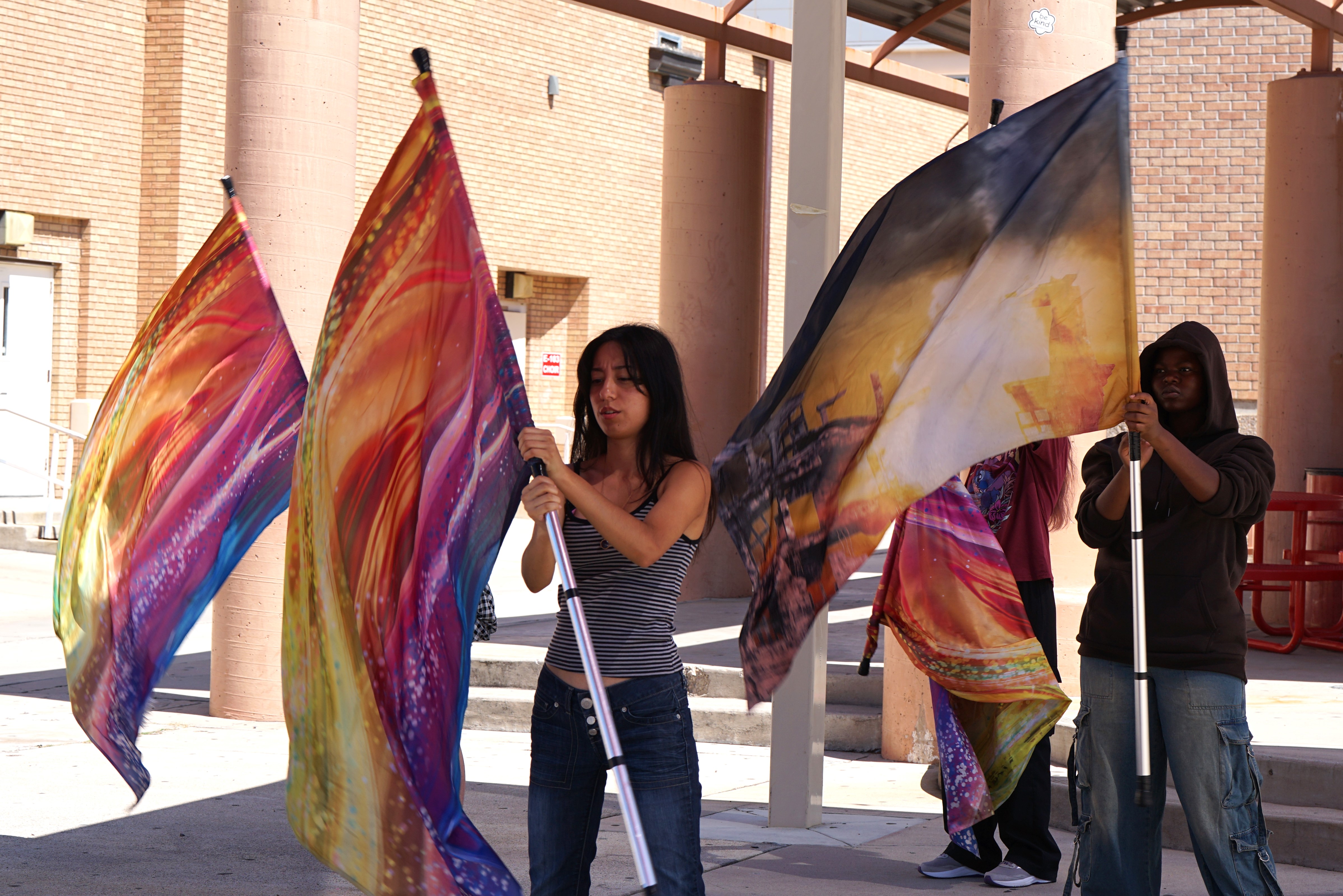 Colorguard students practice twirling their flags