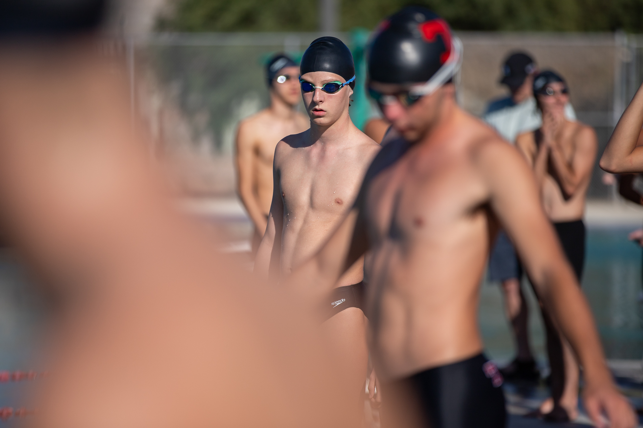 Tucson High swimmers stand around the pool