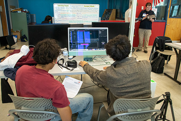 Two teen boys work on a computer