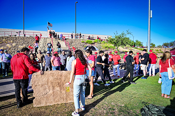 A crowd gathers in front of the new sign at the baseball field