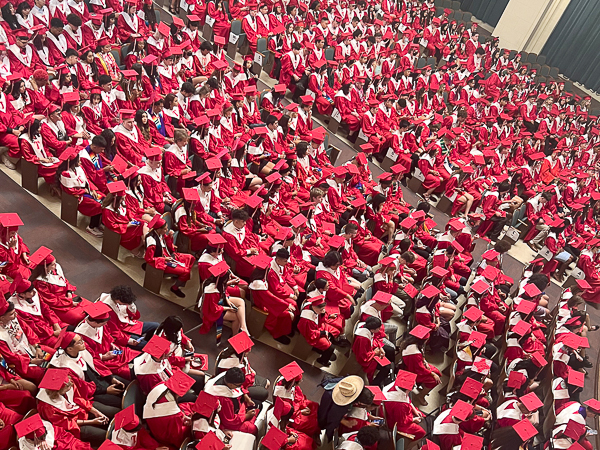 Students ready to graduate fill an auditorium.