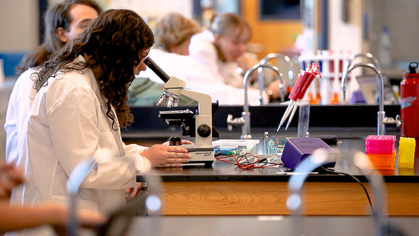 Biology student uses a microscope.