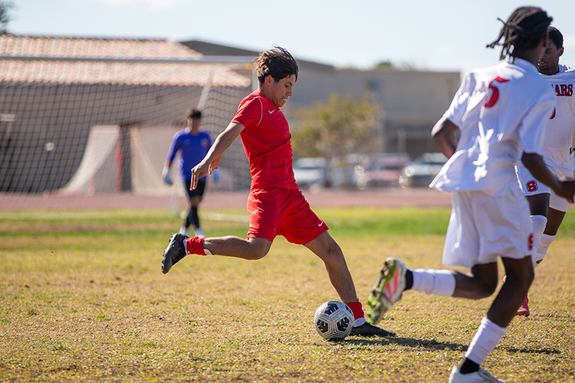 A Tucson High player kicks the soccer ball across the field