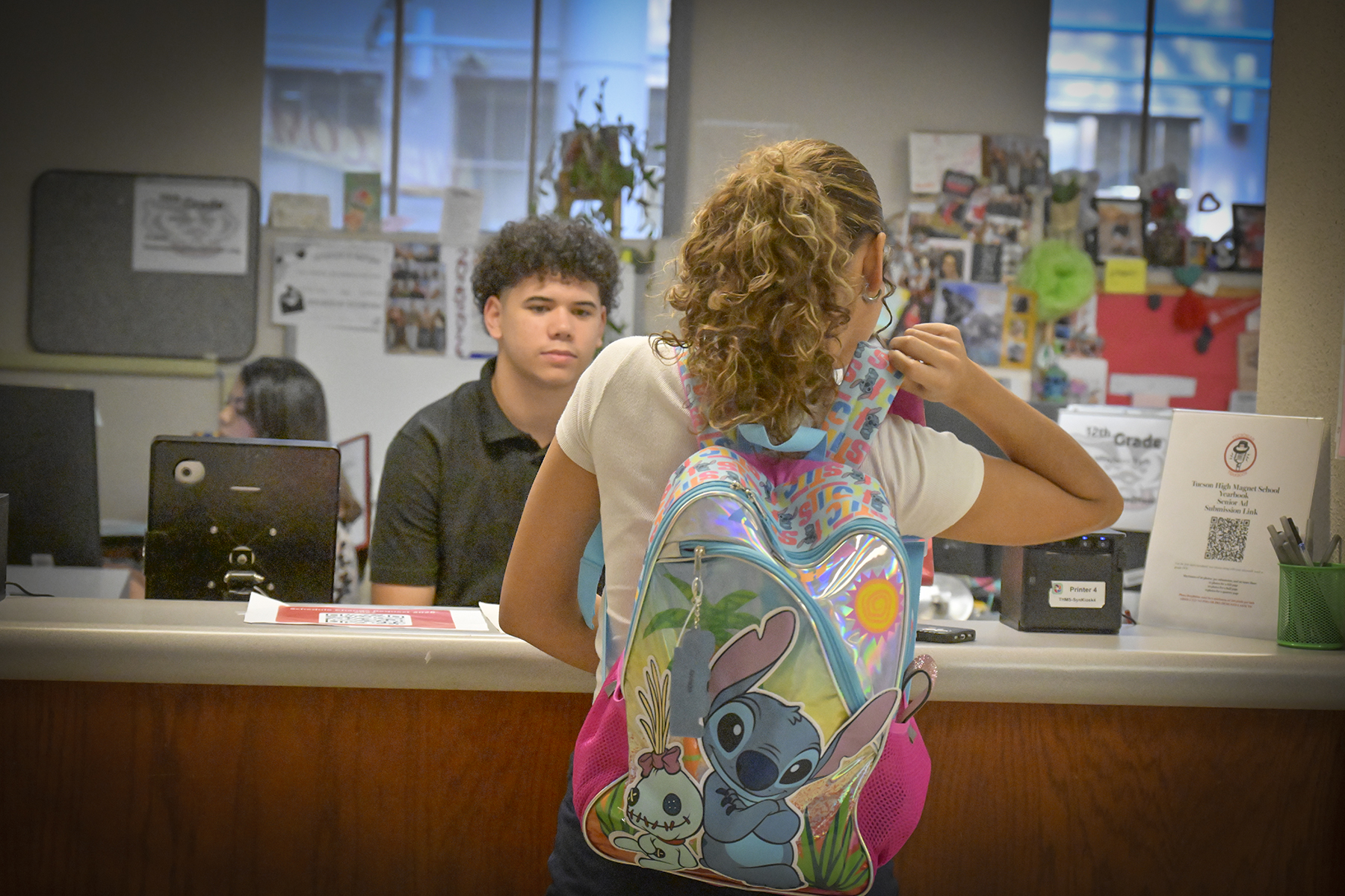 A high school girl talks to the front office staff
