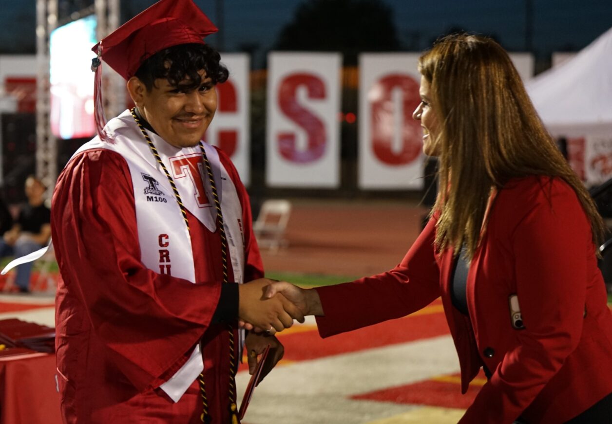 A Tucson High grad smiles as he receives his diploma